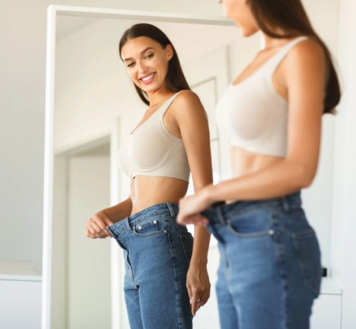 woman looking in the mirror after losing weight