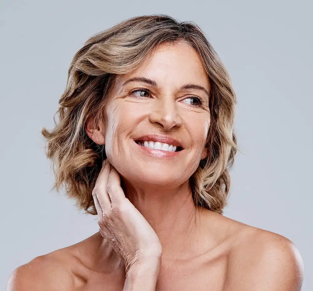 happy woman in her 60s smiling after a facelift